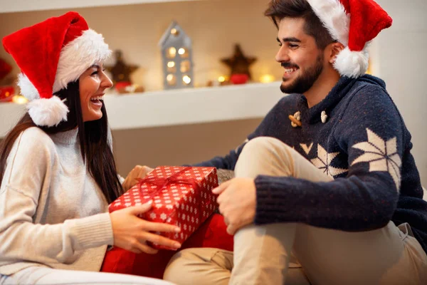 Regalo di Natale. Coppia felice in cappello di Babbo Natale con regalo di Natale — Foto Stock