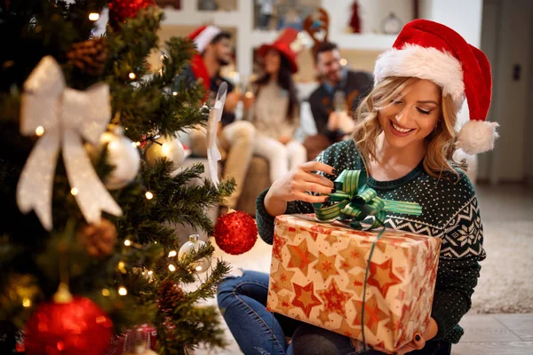 Glückliches Mädchen mit Weihnachtsmütze und Weihnachtsgeschenken zu Hause — Stockfoto