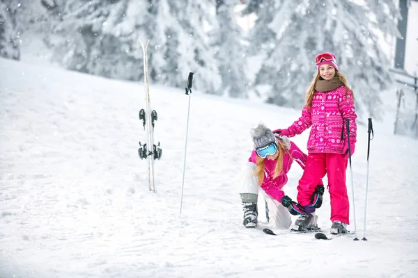 Mãe preparando filha para esquiar — Fotografia de Stock