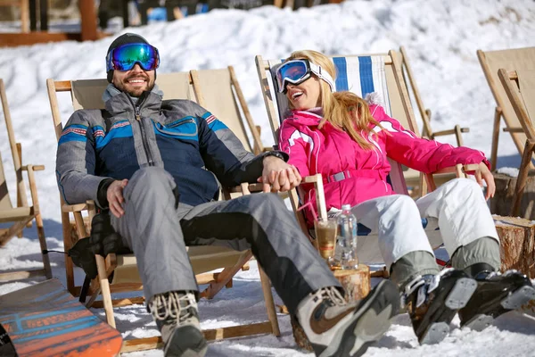 Homem e mulher esquiadores sentados na espreguiçadeira — Fotografia de Stock