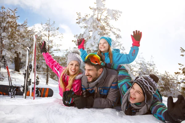 Familia junta en la nieve en las vacaciones de invierno —  Fotos de Stock