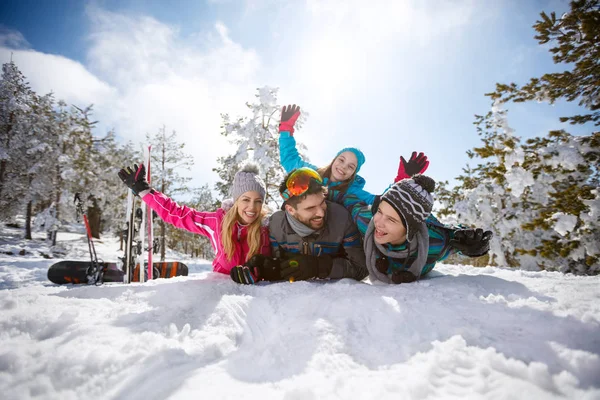 Familia joven divirtiéndose en la nieve en la montaña — Foto de Stock