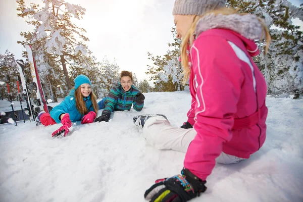 Мать с детьми на лыжах отдыхает на снегу — стоковое фото