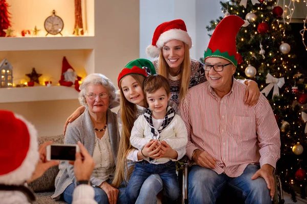 Fotografování k Vánocům usmívající se rodina s smartphone — Stock fotografie