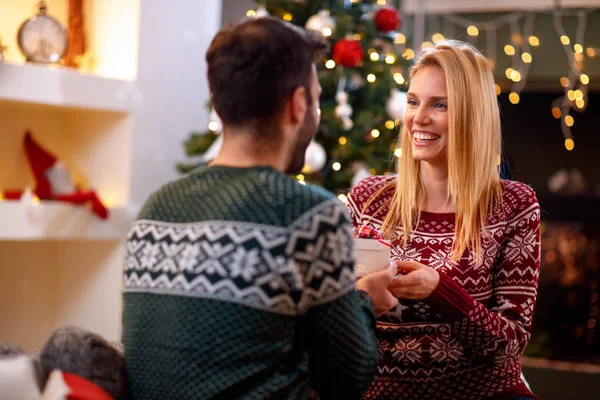 Navidad, vacaciones y concepto de personas - pareja encantadora con regalo de Navidad en casa —  Fotos de Stock