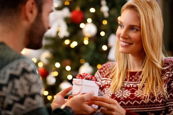 Frau macht ihrem Mann ein Weihnachtsgeschenk — Stockfoto