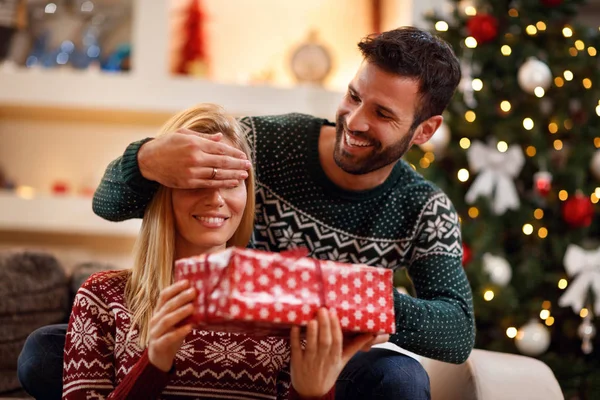 Uomo che copre gli occhi alla donna quando si dà regalo di Natale — Foto Stock