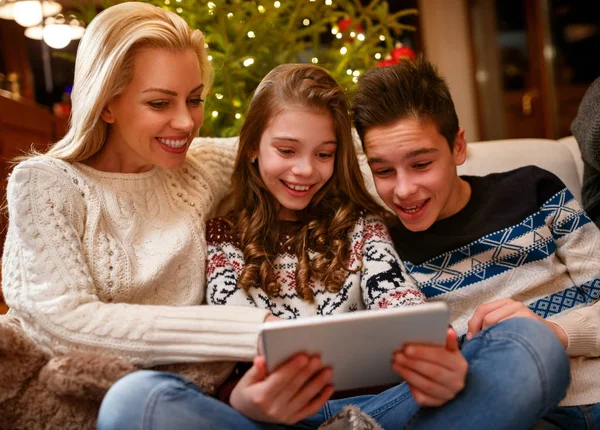 Moeder met kinderen op zoek naar foto's op Tablet PC — Stockfoto