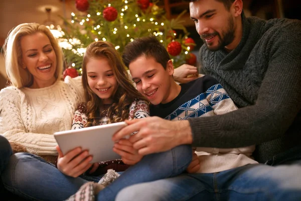 Familie samen voor Kerstmis op zoek foto's op Tablet PC — Stockfoto