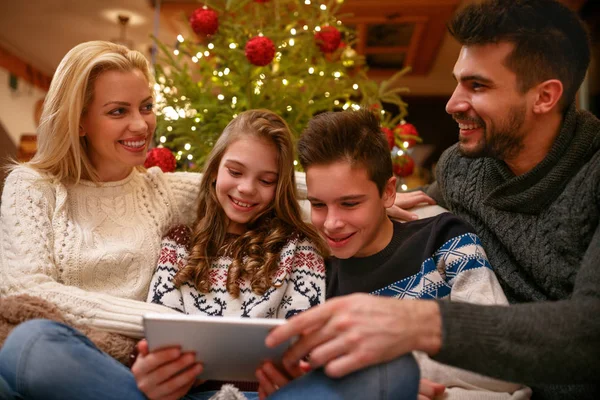 Familie som har det gøy mens de ser på julebilder sammen – stockfoto