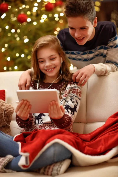 Hermano y hermana disfrutan en Nochebuena con música de tablet —  Fotos de Stock