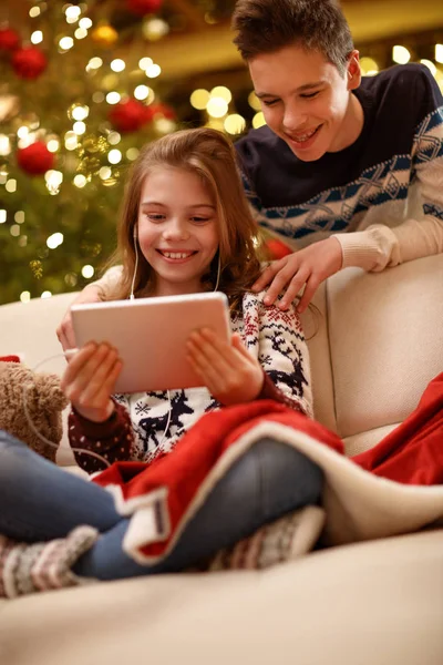 Chica escuchando música y disfrutar con su hermano para la víspera de Navidad —  Fotos de Stock