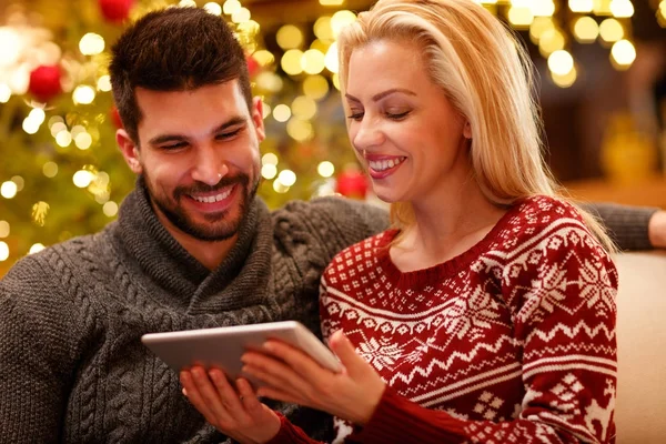 Pareja disfrutando con la tableta en vacaciones de Navidad — Foto de Stock