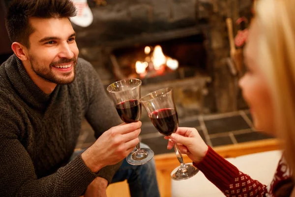 Para zakochanych, siedząc na podłodze o spalania kominek i pić wina — Zdjęcie stockowe