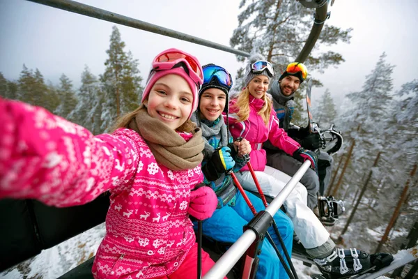 Esquí, telesilla, estación de esquí - esquiadores familiares felices en telesilla haciendo selfie — Foto de Stock