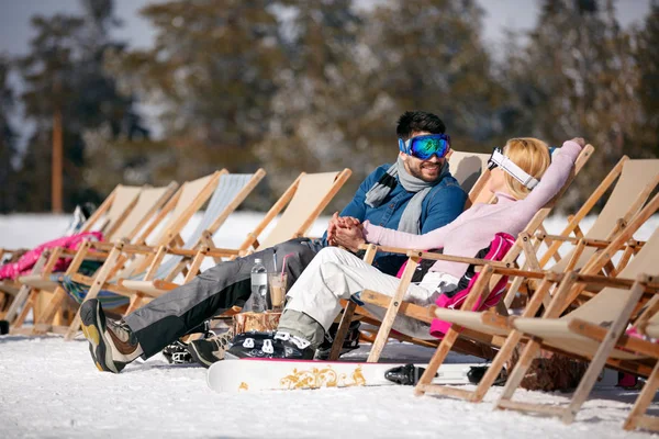 Férias de inverno, esqui, viagens - casal relaxando juntos ao sol nas montanhas — Fotografia de Stock