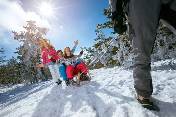 Familie im Schnee hat Spaß beim Rodeln an sonnigen Wintertagen — Stockfoto