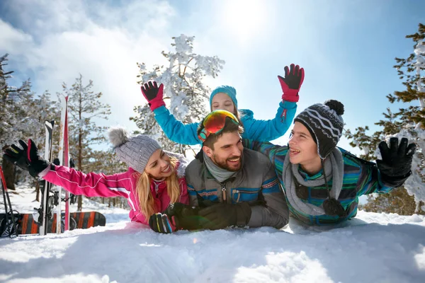 Familia joven divirtiéndose en nieve fresca en vacaciones de invierno — Foto de Stock