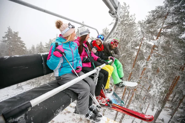 Friends skier sitting at ski chair lift in beautiful sunny day — Stock Photo, Image