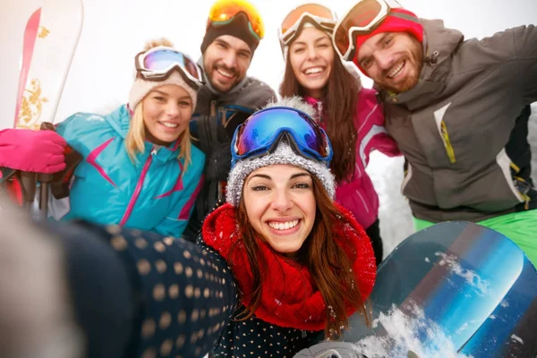 Amigos felices divirtiéndose en la nieve. grupo de snowboarders y esquiadores —  Fotos de Stock