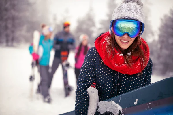 Sportif erkek gülümseyen snowboard dağlarda kış tutar