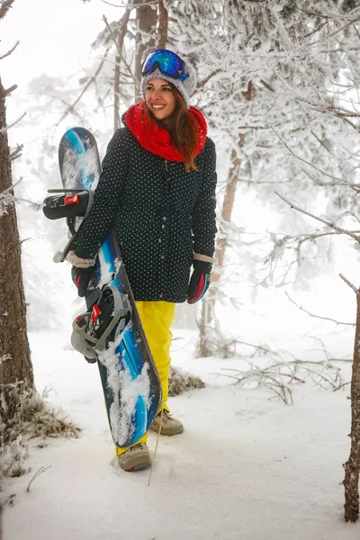 Flicka snowboardåkare går igenom i skogen dimma vinter — Stockfoto