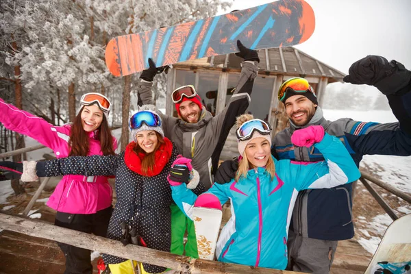 Group of happy friends on cold winter day at mountain cottage an — Stock Photo, Image