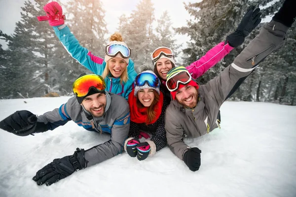 Лыжники лежат на снегу и веселятся — стоковое фото