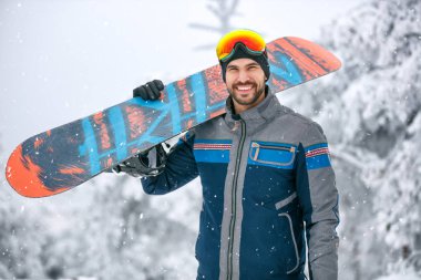 Snowboard Kayak arazi üzerinde tutan adam