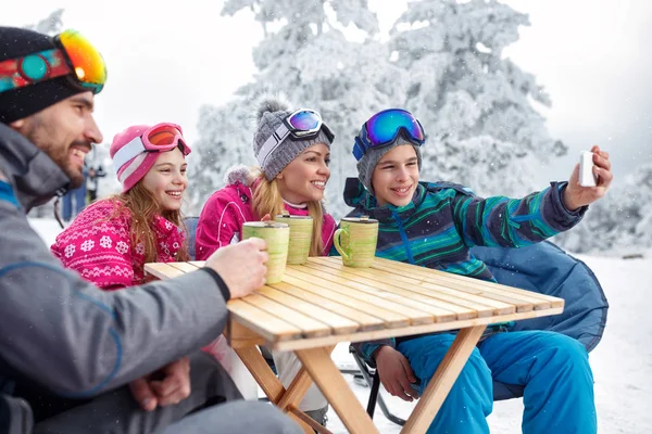 Jongen maken selfie met familie in café op ski-terrein — Stockfoto