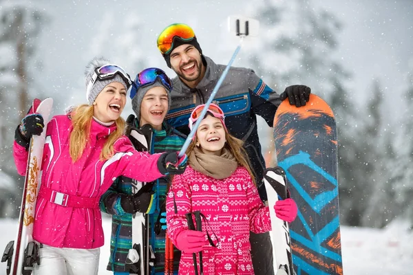 Família tirando foto selfie enquanto esquiava na neve — Fotografia de Stock