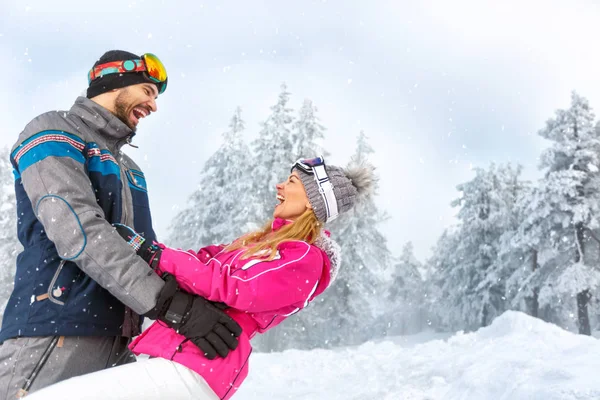 Homem e mulher se divertindo na natureza nevada na montanha — Fotografia de Stock