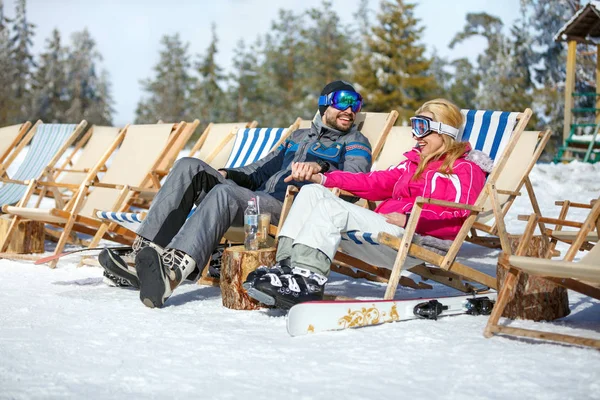 Skifahrer-Paar in Liegestühlen genießt Sonne — Stockfoto