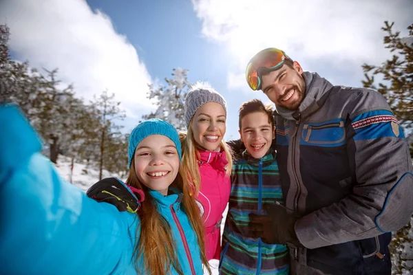 Glückliche Kinder mit Eltern beim Skifahren — Stockfoto