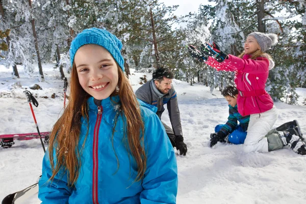 Flicka på skidåkning med föräldrar och bror — Stockfoto