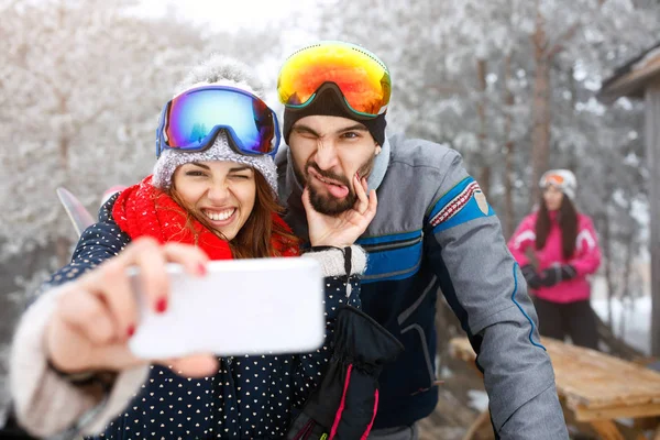 Skiërs paar buiten nemen selfie — Stockfoto