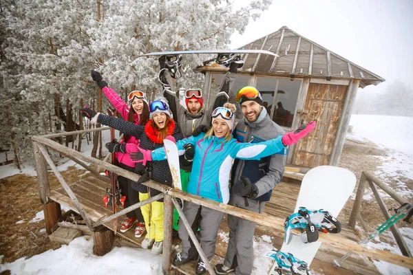 Grupo de esquiadores en casa de madera de invierno — Foto de Stock