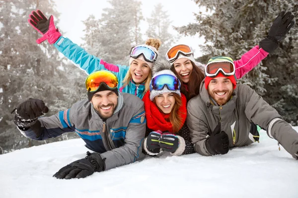 Freunde auf Skiern liegen zusammen im Schnee — Stockfoto