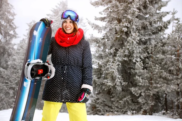 Idrottskvinna med snowboard i berg — Stockfoto