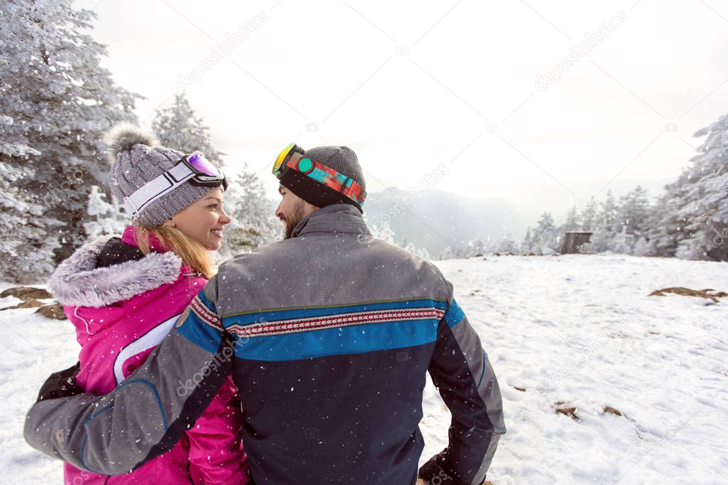 Woman and man in love on winter holiday together, back view