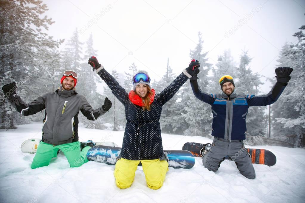 Female with male snowboarders kneeling on snow