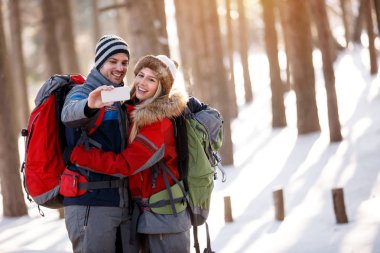 Oğlan ve kız alarak fotoğraf karlı doğada