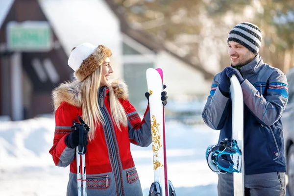 Couple of skiers with skis on snowy mountain — Stock Photo, Image