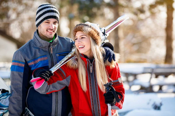 Jeune couple apporter des skis sur l'épaule — Photo