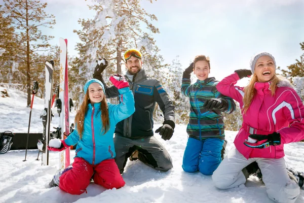 Família desfrutando de férias de inverno nas montanhas. Esqui, sol, neve e diversão — Fotografia de Stock