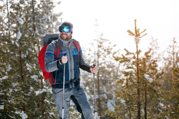 Пешие прогулки в горах зимой - Молодой человек ходит в лес — стоковое фото