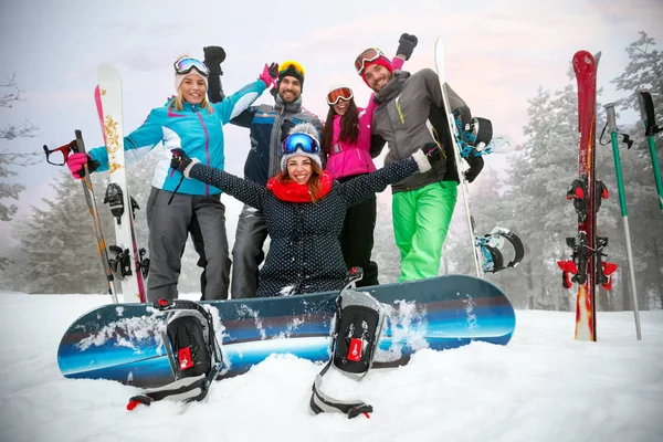 Amigos felices snowboarders y esquiadores se divierten en la pista —  Fotos de Stock