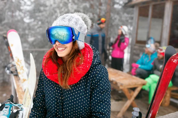 Smiling girl and friends spend winter holidays at mountain cottage — Stock Photo, Image