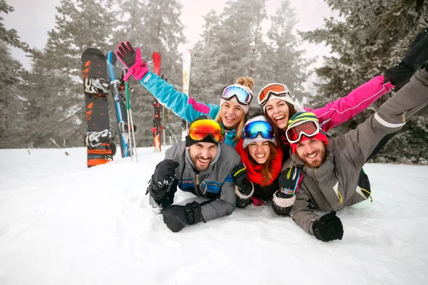 Groep skiërs liggend op sneeuw en plezier — Stockfoto