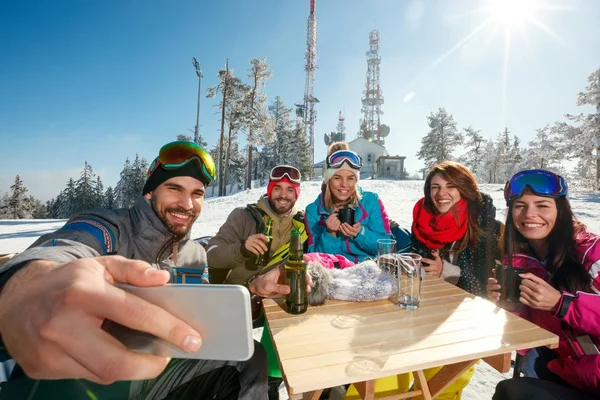 Smiling friends taking selfie in cafe at ski resort — Stock Photo, Image